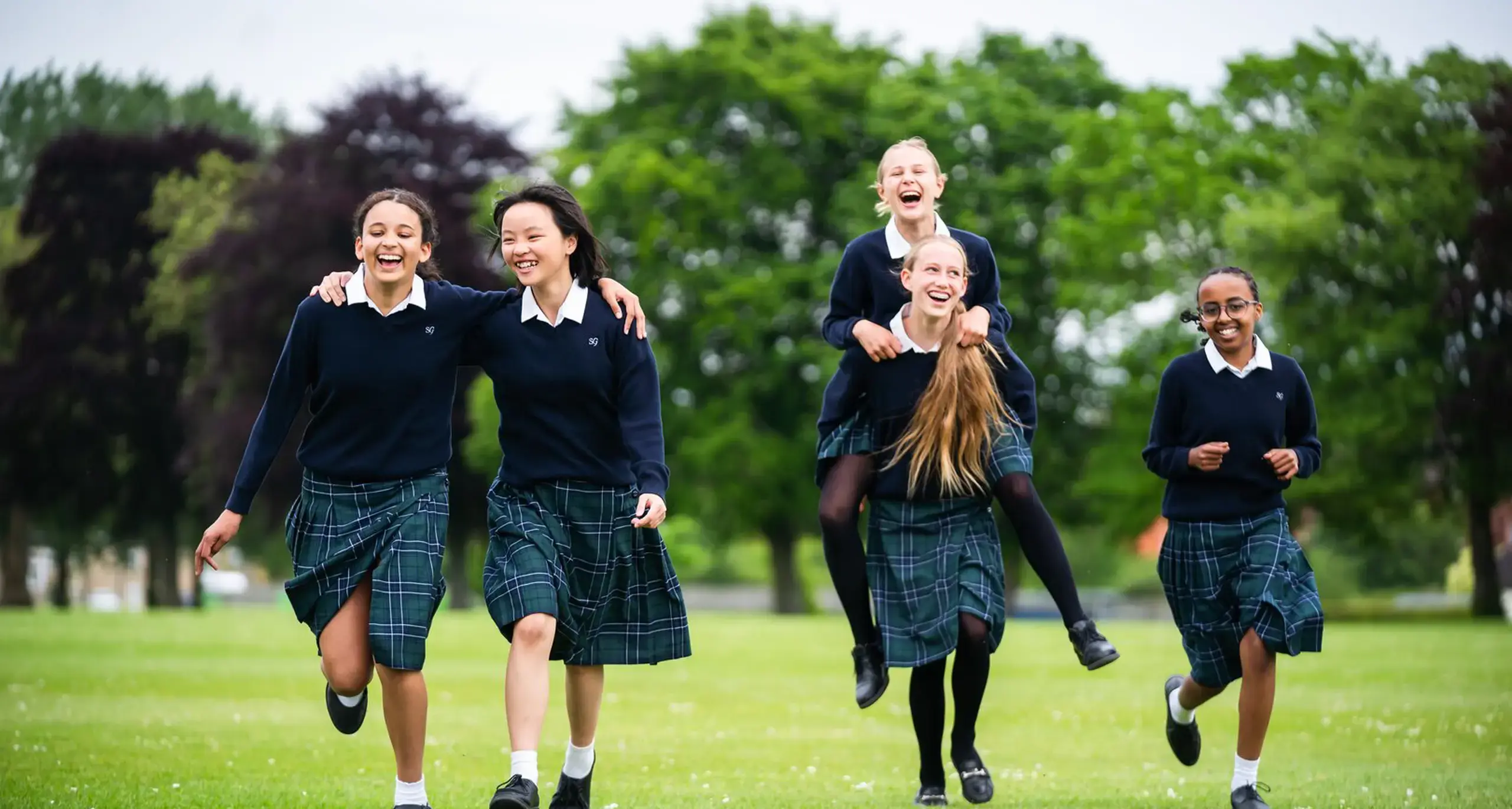 Students Laughing and Playing in Field Together