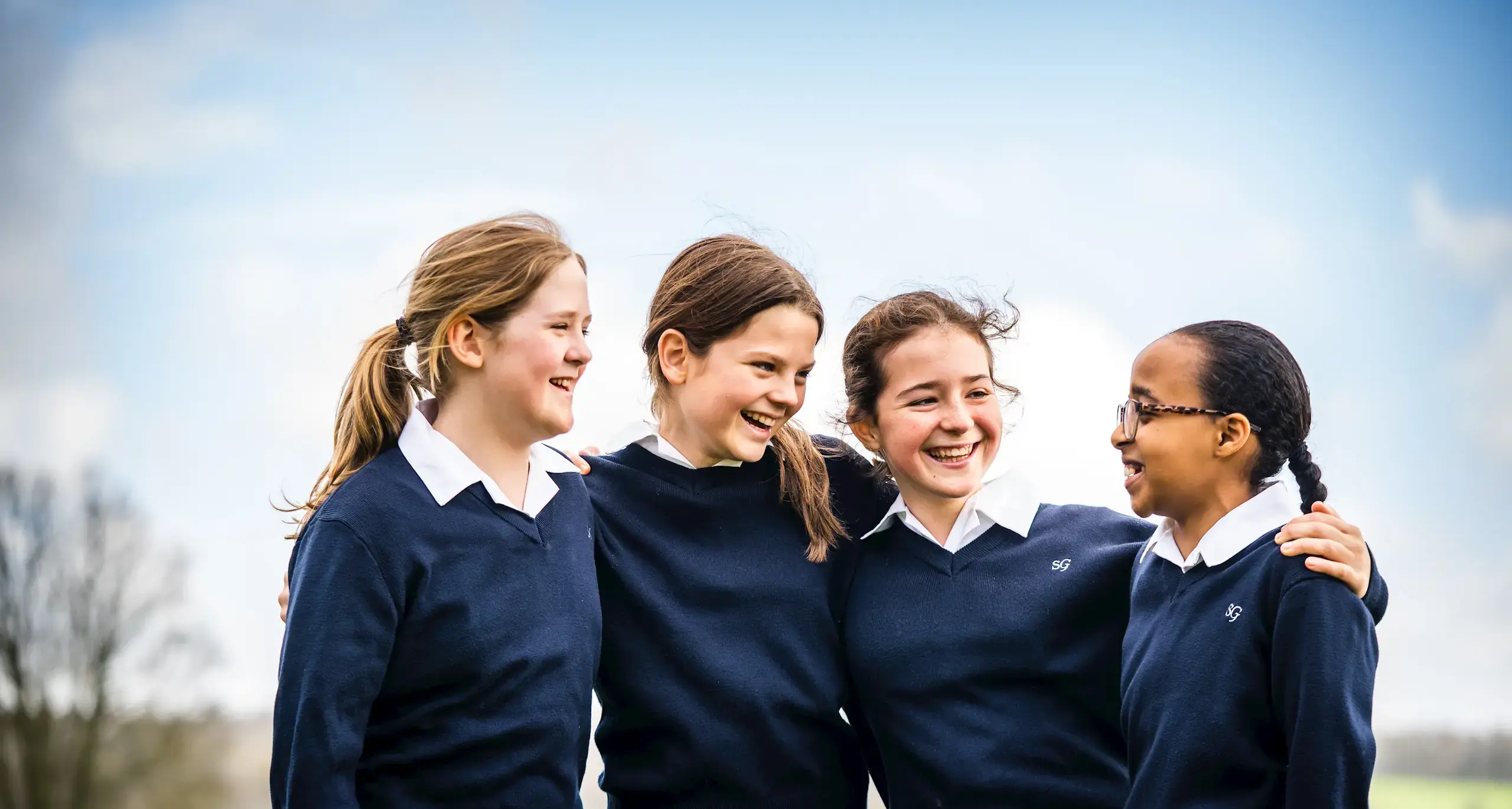 Group of Students in Field Laughing and Smiling
