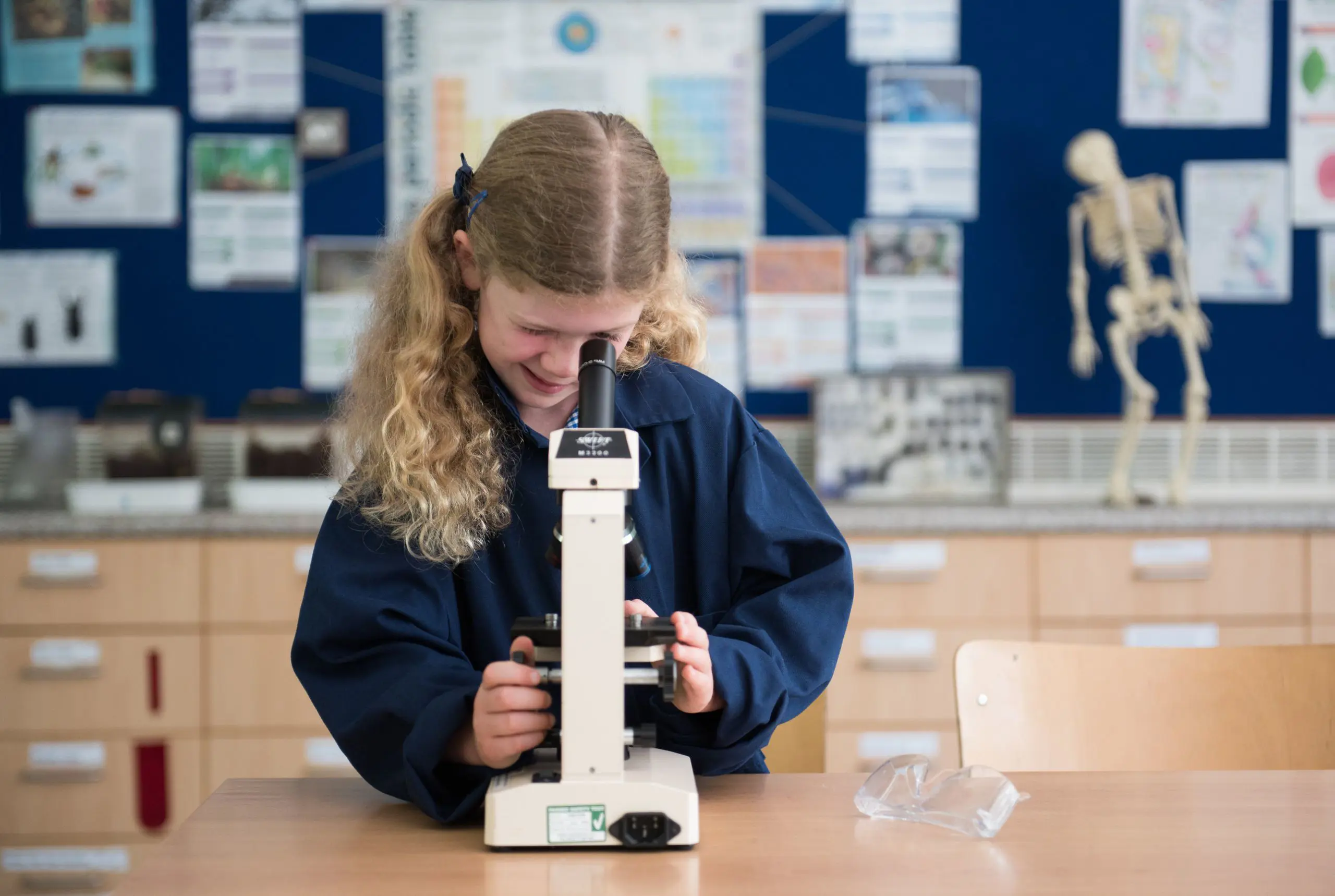 Student Looking Down Microscope