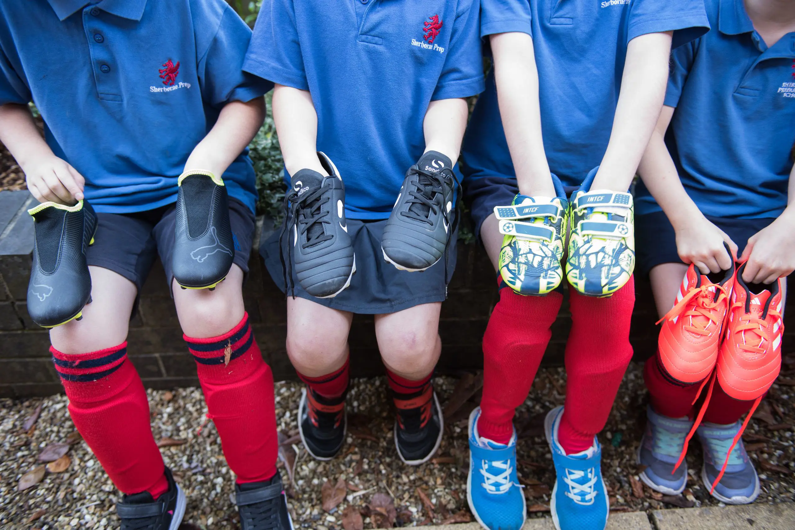 Students During Sports Class Holding Theor Cleats