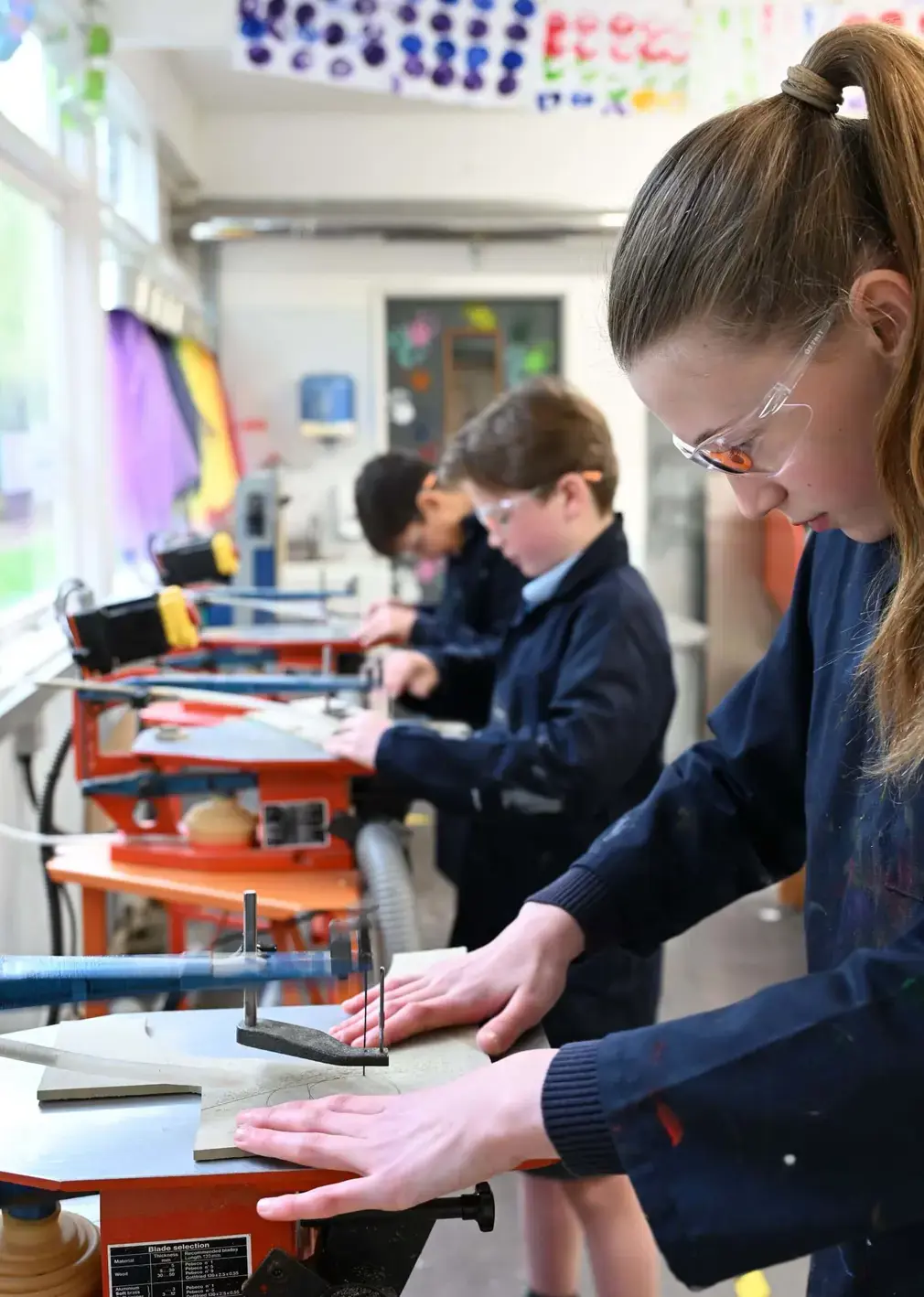 Sherborne Prep student using a jigsaw to cut wood.