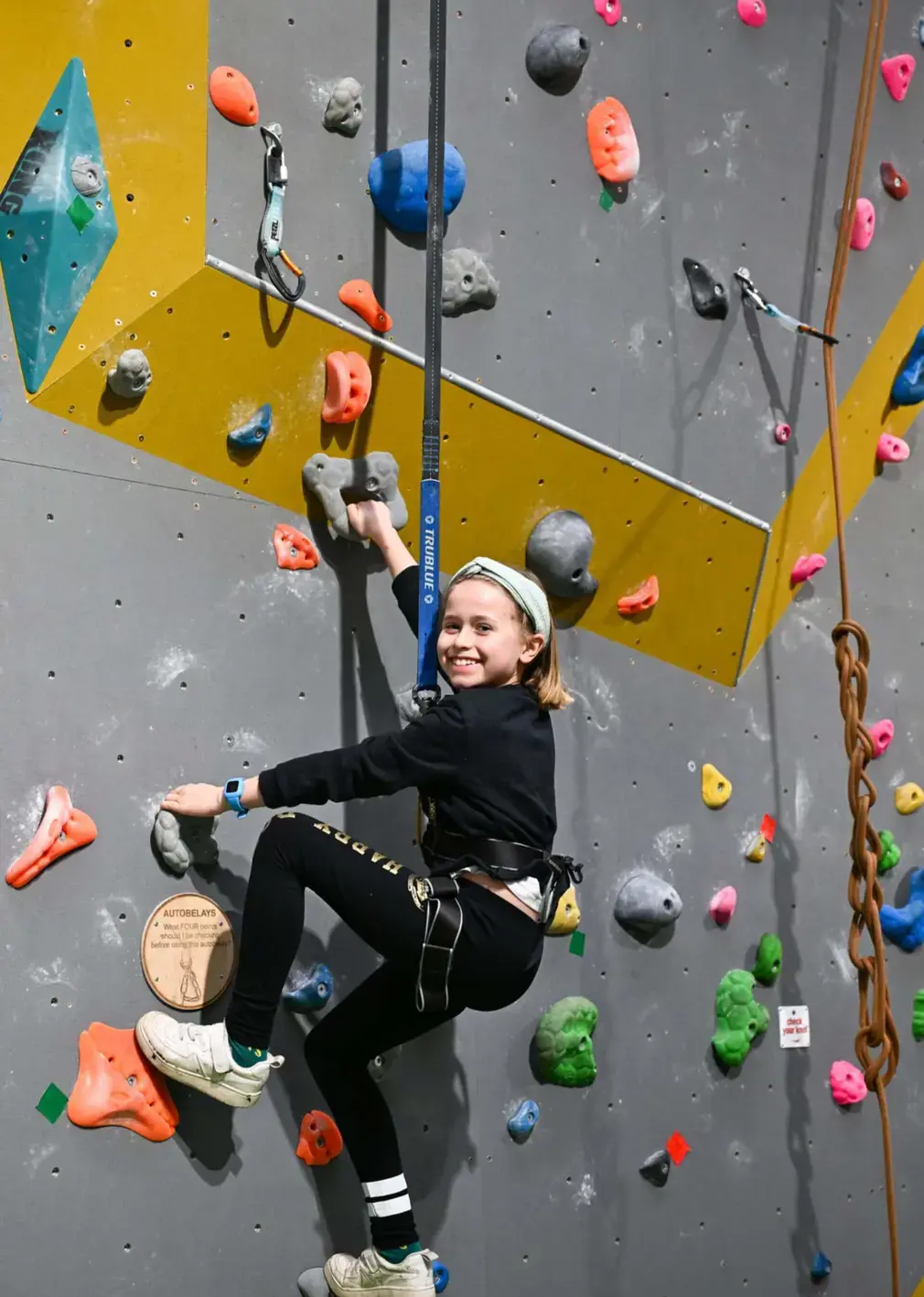 Sherborne Prep student scaling a rock climbing wall.