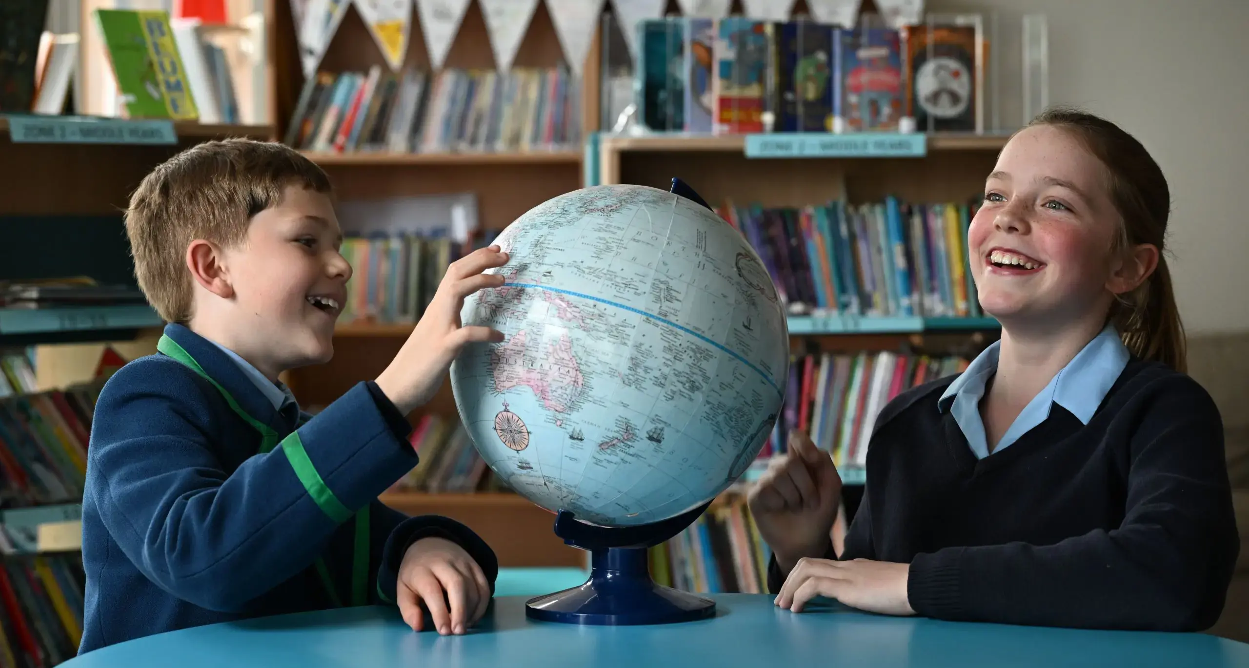 Student Studying Globe and Laughing