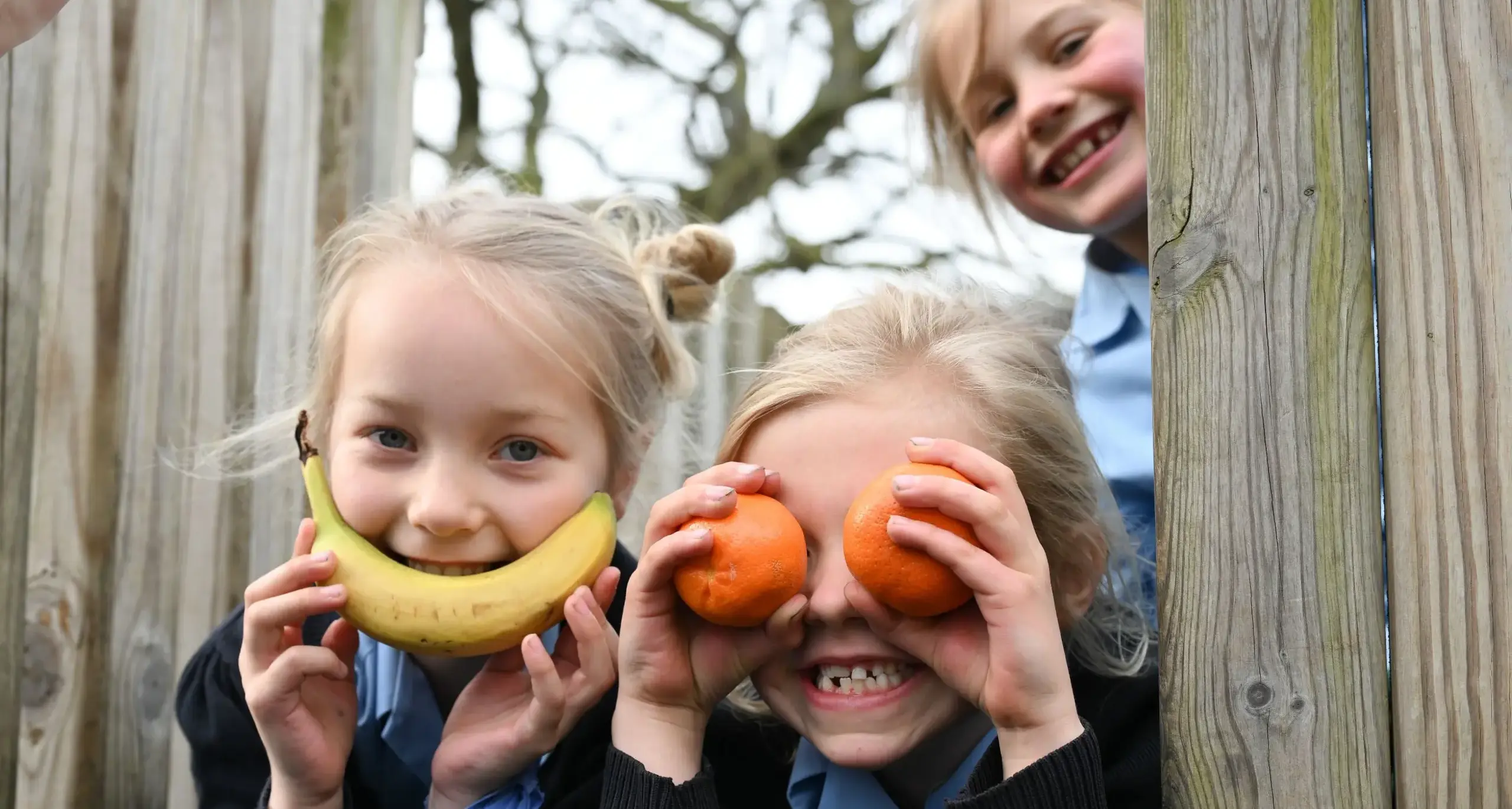 Students on Playset Smiling and Playing with Fruit
