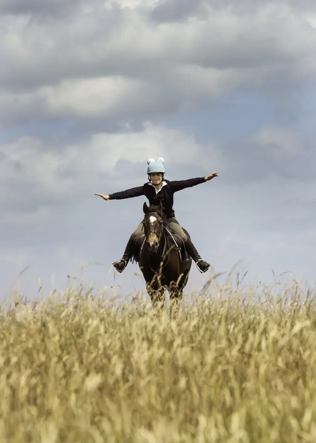 Horse rider galloping through fields