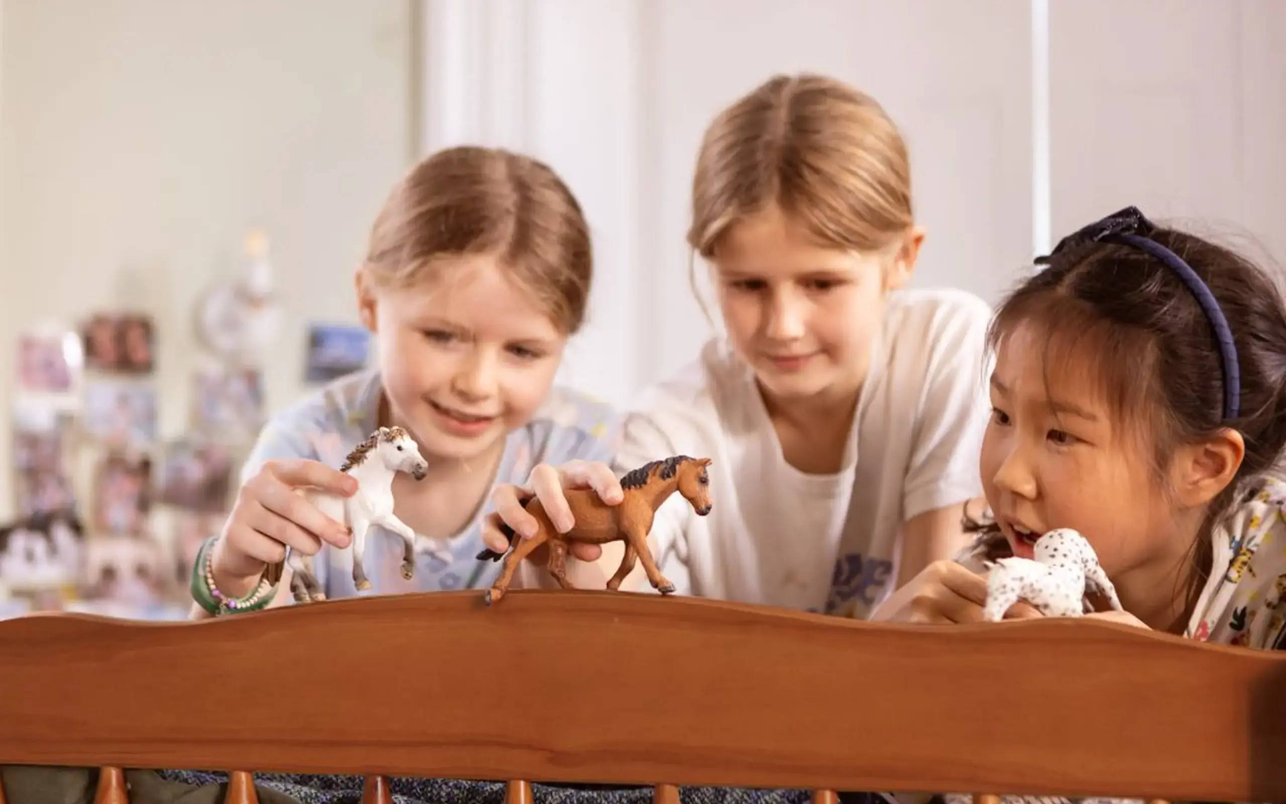 Students playing with toy horses on bedframe