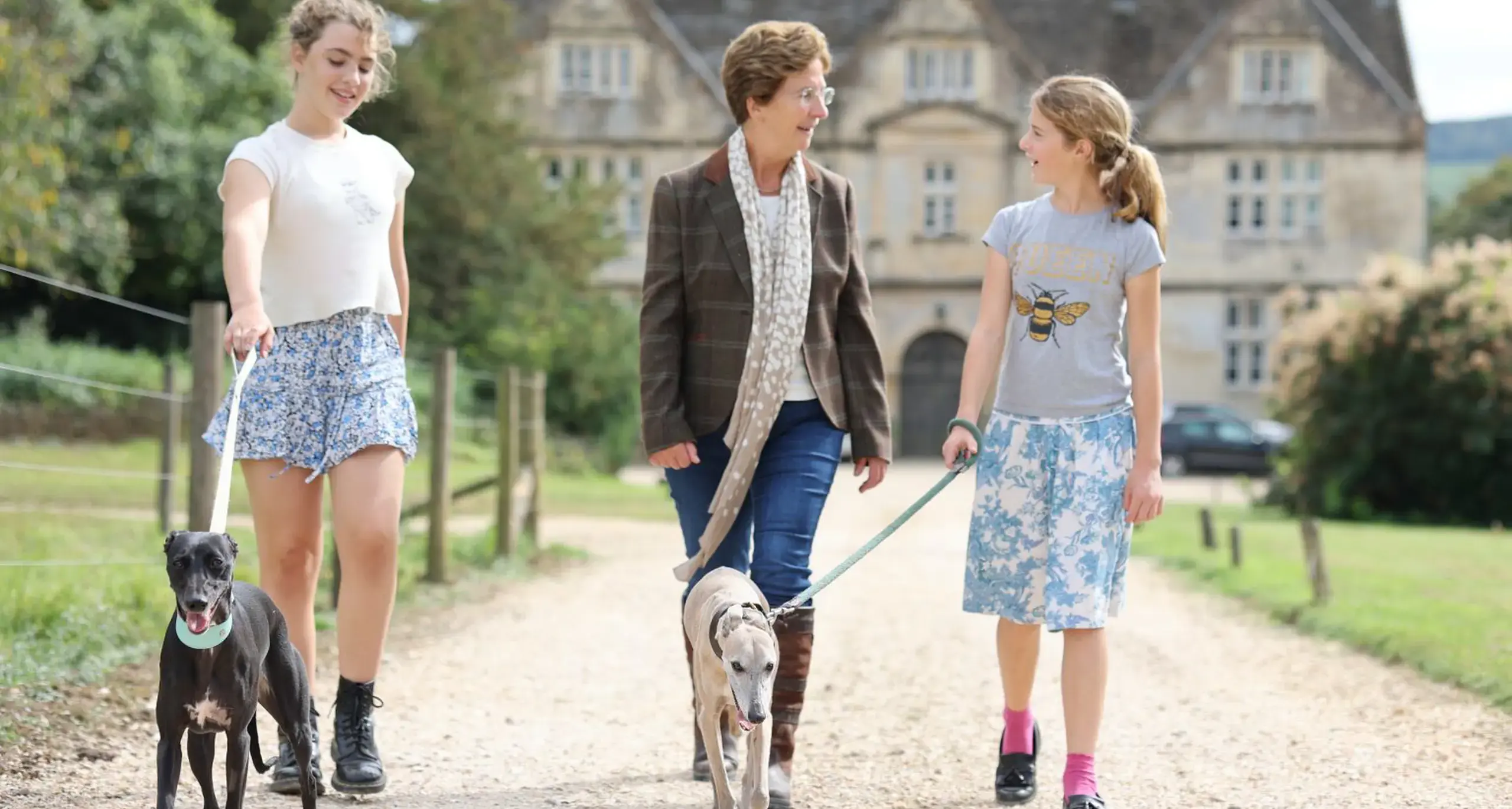 Girls and Head of School Walking Dogs on Campus
